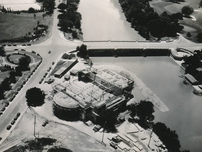 image from https://nddaily.blogspot.com/2017/06/
‘The Works Progress Administration built the Inland Naval Armory, also known as the Heslar Naval Armory.
According to historian Glory-June Greiff, “[…] the stunning WPA-built Naval Armory, the work of architect Ben H. Bacon, has graced the bank of the non-navigable White River since before its dedication in October 1938.  At the time of that first publication, the glorious Art Moderne building still somewhat served its original function and was gloriously intact outside and in, including the over-the-top nautical decor of the Officers’ Mess.  The interior was originally fitted with a simulated navigation bridge and many other accoutrements of a naval vessel. Inside the drill room–essentially a large gymnasium–are four huge murals of famous naval battles by WPA artist Charles Bauerle. Today the building serves as a school.’
- https://livingnewdeal.org/projects/heslar-naval-armory-indianapolis-in/
