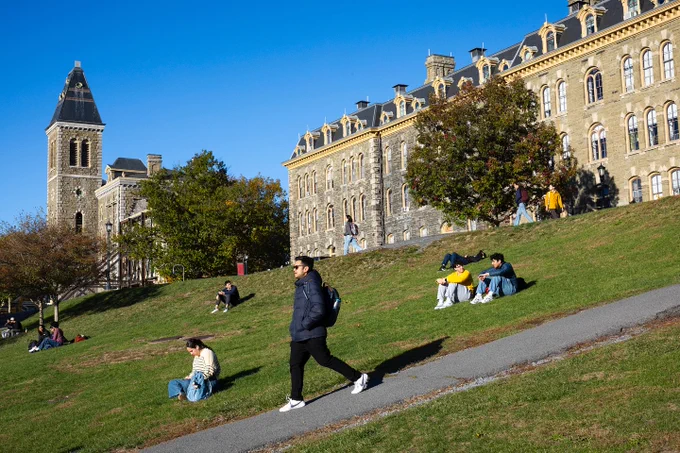 Several people enjoying a sunny day on the Cornell University Slope.