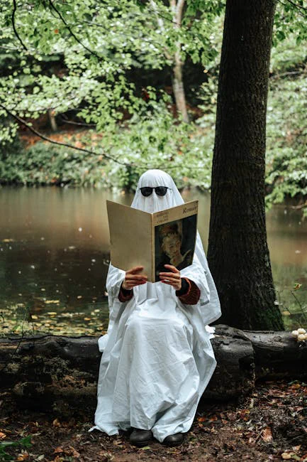 A mysterious figure in white reads by the river, blending Halloween and nature themes.