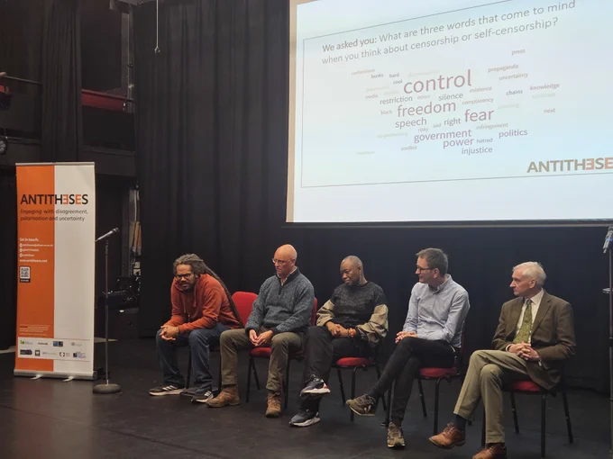 Photo of a panel with 5 members sitting down on chairs