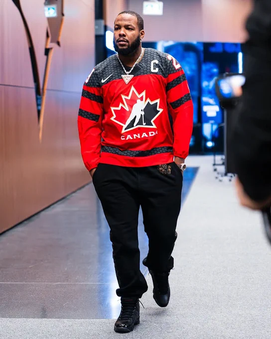 Vladimir Guerrero Jr. walking into Ragers Centre. He's wearing a red and black No. 29 Marie-Philip Poulin Team Canada hockey jersey. 