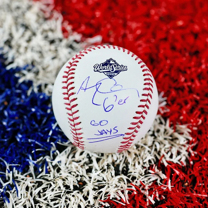 A 2025 World Series baseball autographed by Drake. The ball sits on a painted logo background.