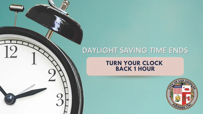 Close-up of a traditional black alarm clock showing 2:00, alongside text reading "Daylight Saving Time Ends — Turn Your Clock Back 1 Hour," with the City of Los Angeles seal in the corner.