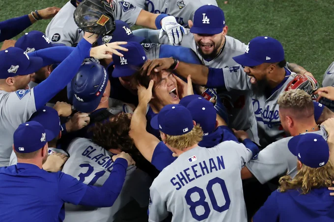 Yoshinobu Yamamoto is swarmed by Dodgers teammates after recording the final outs of World Series Game 7.