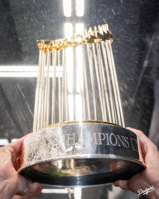 A photo of the World Series trophy in the air with champagne being poured over it.