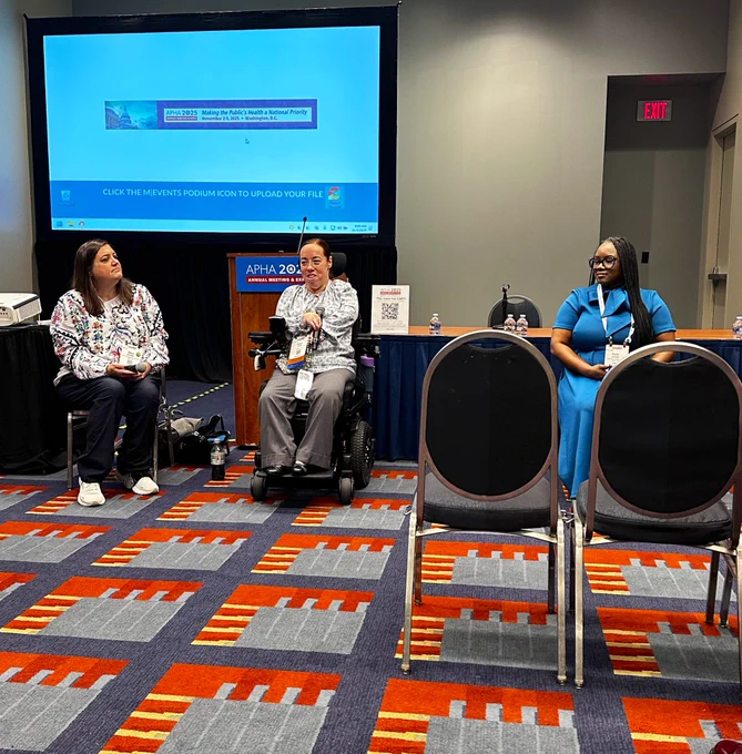 A group of people are in front of a conference meeting room leading a session.