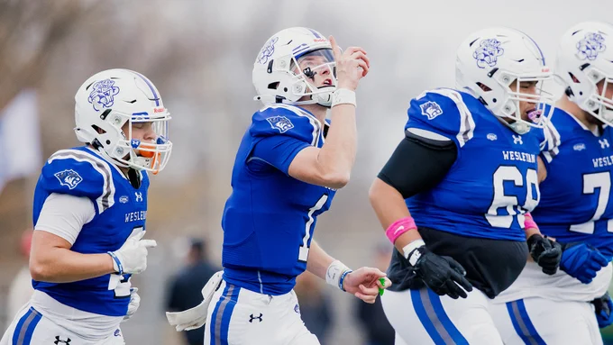 Connor Drake pointing to the sky as he runs onto the field, photo by ThirDWheel Photo