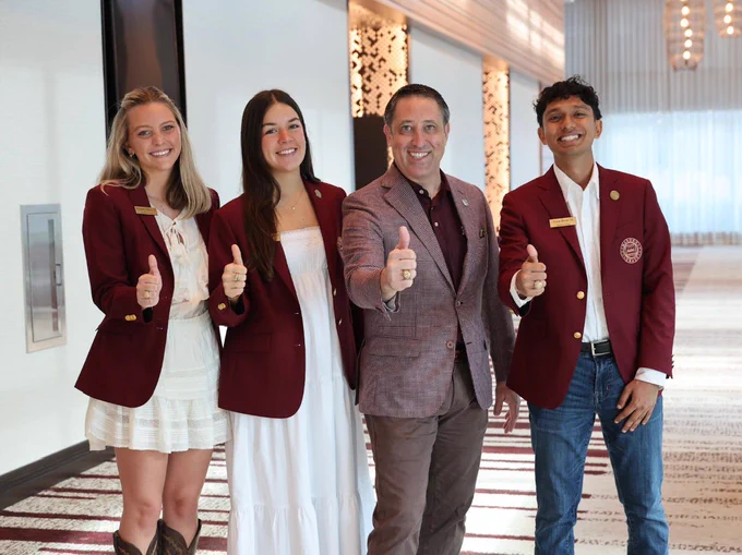 Chancellor Hegar stands with the maroon coats