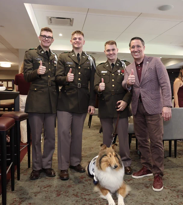 Chancellor Hegar stands with Reveille and her handlers