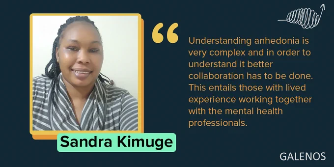 A pritty woman in a striped top smiles at the camera with a quote overlaid in orange text: "Understanding anhedonia is very complex and in order to understand it better collaboration has to be done. This entails those with lived experience working together with the mental health professionals. "