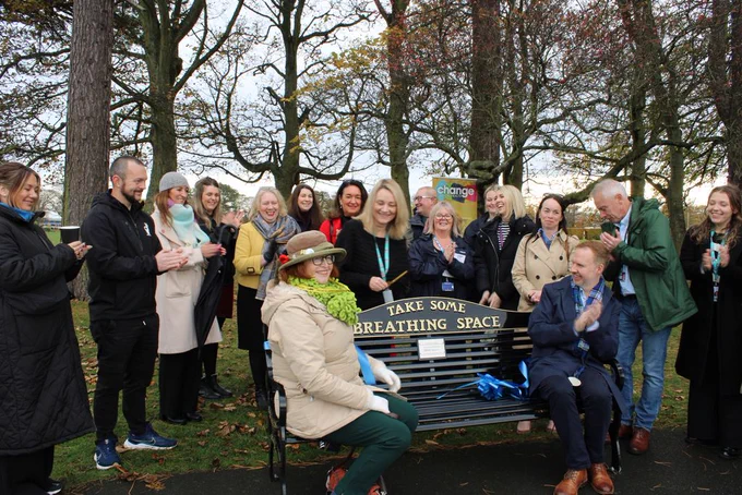From left, seated – Cllr. Lesley Backhouse and Nick Ward, CEO of Change Mental Health. Standing behind and around the bench (from left to right) are Cllr. Julie MacDougall in red, Cllr. Kathleen Leslie, Cllr. Ian Cameron, and Lisa-Jane Dock from NHS 24 Breathing Space, alongside local partners including members of Andy’s Men’s Club, staff from Gillespie Macandrew, and representatives from Fife Council, Fife Health and Social Care Partnership, and NHS Fife.