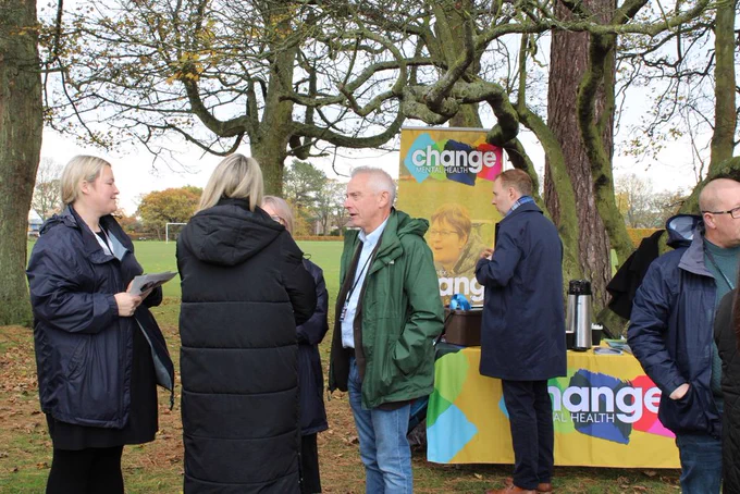 Attendees of the event in the park with Change branding in the background