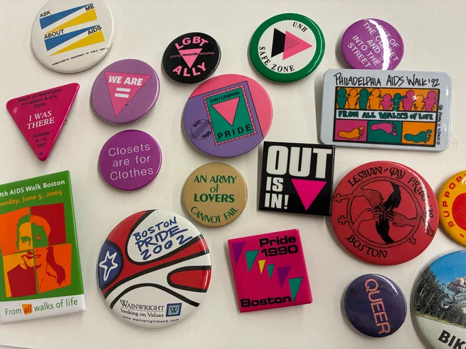 A collection of buttons in a variety of colors with LGBTQ -positive messages