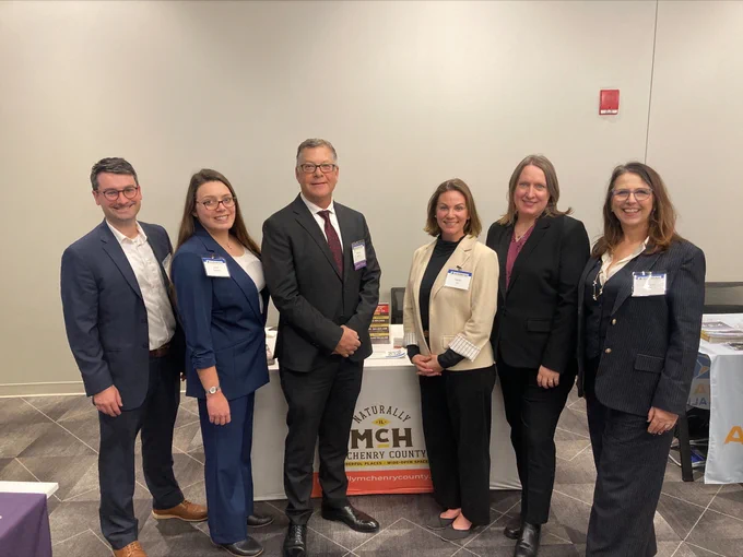 This is a photo of County Board Chairman Mike Buehler, Director of Public Affairs Alicia Schueller, and Assistant County Engineer Scott Hennings, standing with the staff of Naturally McHenry County at the CMAP State of the Region Event.