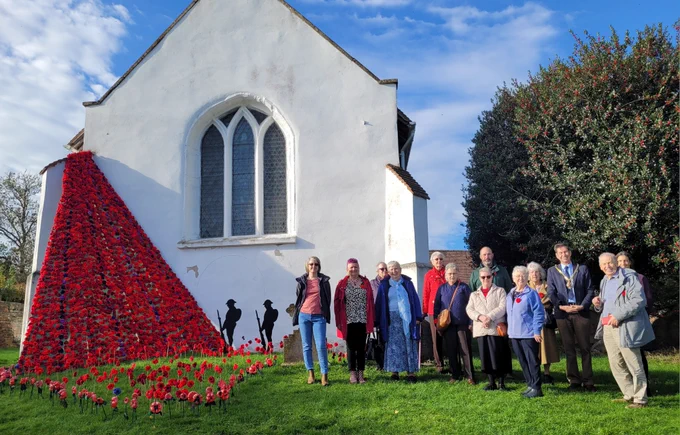 People stood by the poppy display at St Nicholas Church