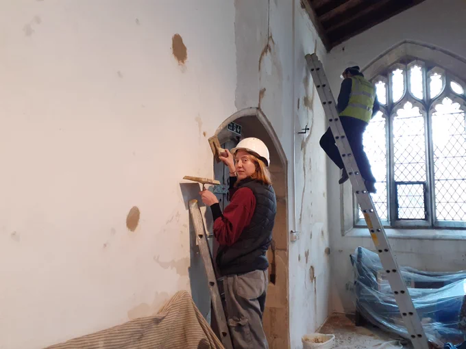 People in hard hats work on the interior of a church.
