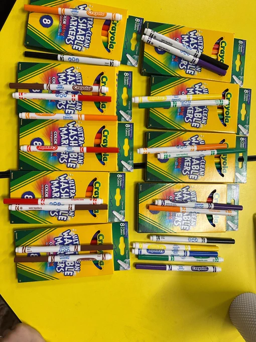 A colorful puzzle in the making — rows of Crayola Ultra-Clean Washable Markers, some boxed and some loose, ready to be sorted and counted