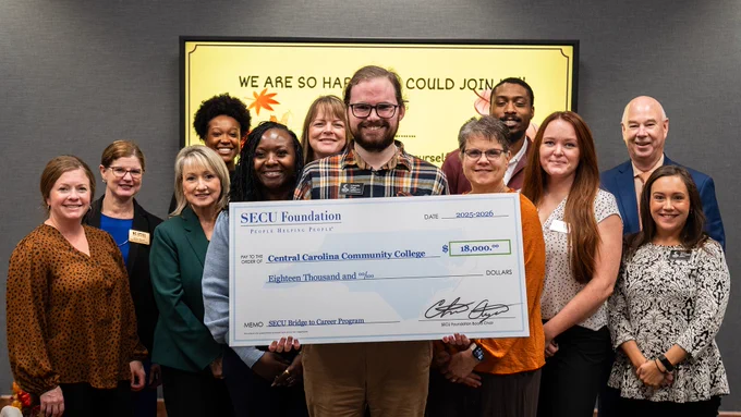 Students and Faculty pose with donation check from SECU