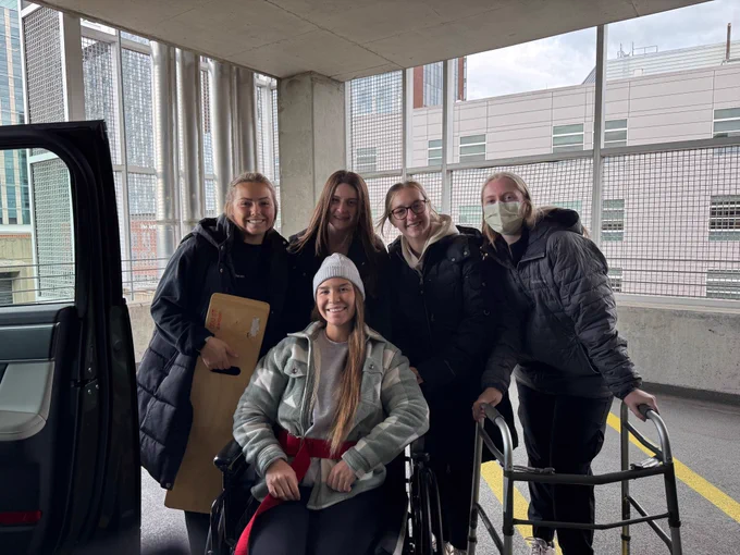 2nd year ot students practicing functional mobility to get into a car using a sliding board, gait belt, wheelchair, and walker. From left to right, Claire, Abigail, Bella, Bethlehem, and bottom, Sophie