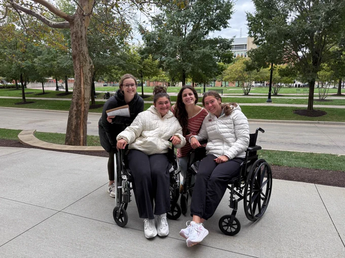 Group picture of 2nd year ot students, Kylie, Felicity, Maria, and Sam practicing functional mobility outside of Atwell