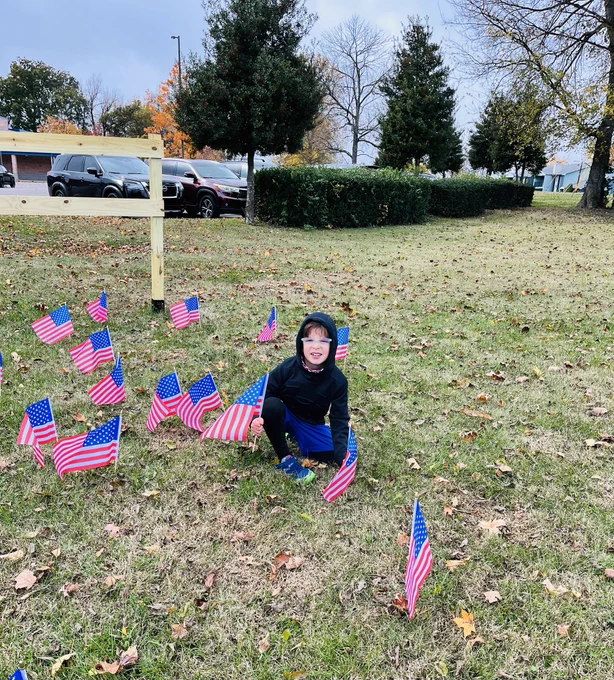 Boy putting a flag in the ground.