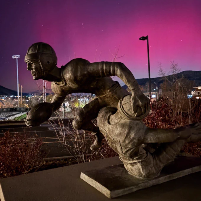 A statue of a football player with the Aurora borealis behind it