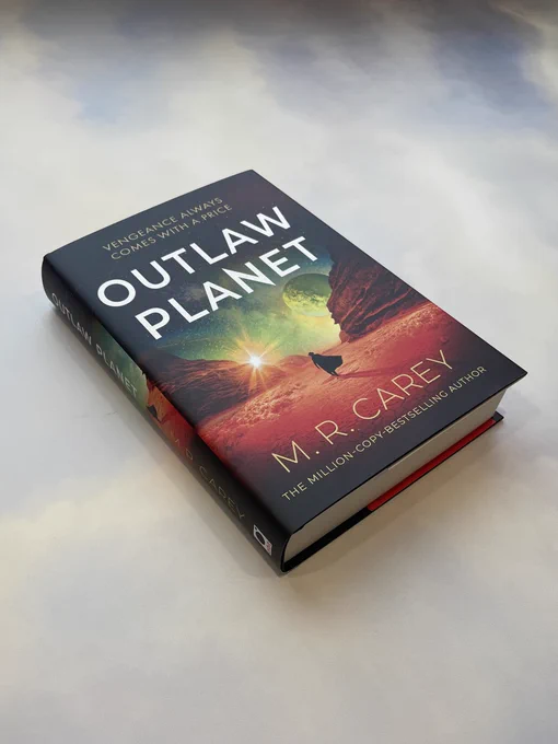 A hardback copy of OUTLAW PLANET by M. R. Carey against a sky-coloured background
