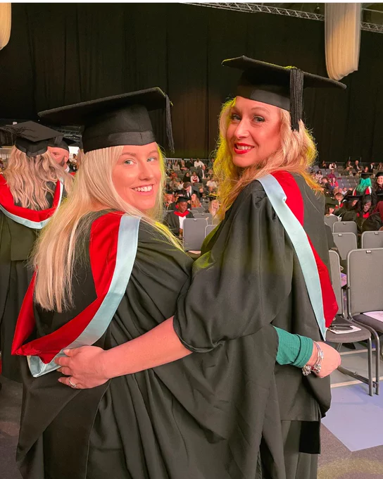 Two friends hug in celebration on University of Derby's graduation day
