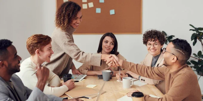 Diverse team collaborating in a meeting, showcasing teamwork and cooperation in a modern workplace.