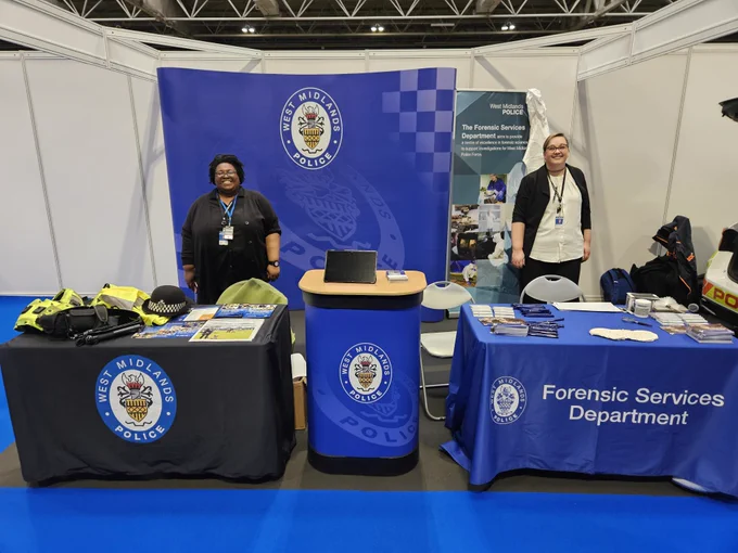 A member of the Outreach team and the Forensics team standing together