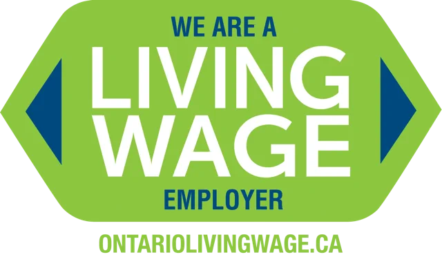 Green sign with blue and white text reading "we are a living wage employer ontariolivingwage.ca"