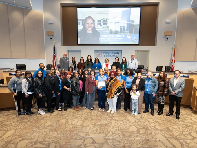 Principal melanie simmons with school board and family at school board meeting after simmons is recognized