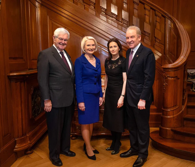Ambassador Callista L. Gingrich and Speaker Newt Gingrich stand with American Swiss Foundation Chair Robert J. Giuffra Jr. and his wife in front of an ornate wooden staircase, smiling at the camera.