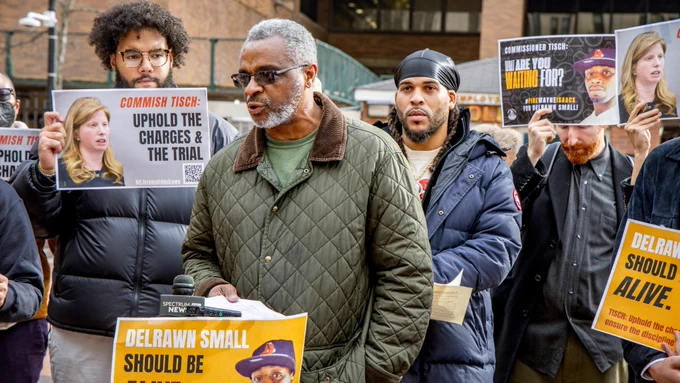 A member of Delrawn Small's family speaks as advocates listen