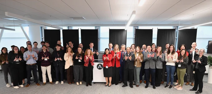 UW–Madison leadership, leaders from Accuray, and Congressional staff pose for a group portrait while making the "W" sign for Wisconsin