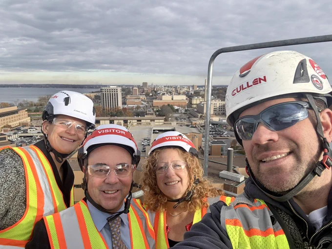 A selfie with Jeannie Cullen Schultz, Vice Chancellor Craig Thompson, Chancellor Mnookin, and Chad Mielke on top of a crane, with a view of campus.