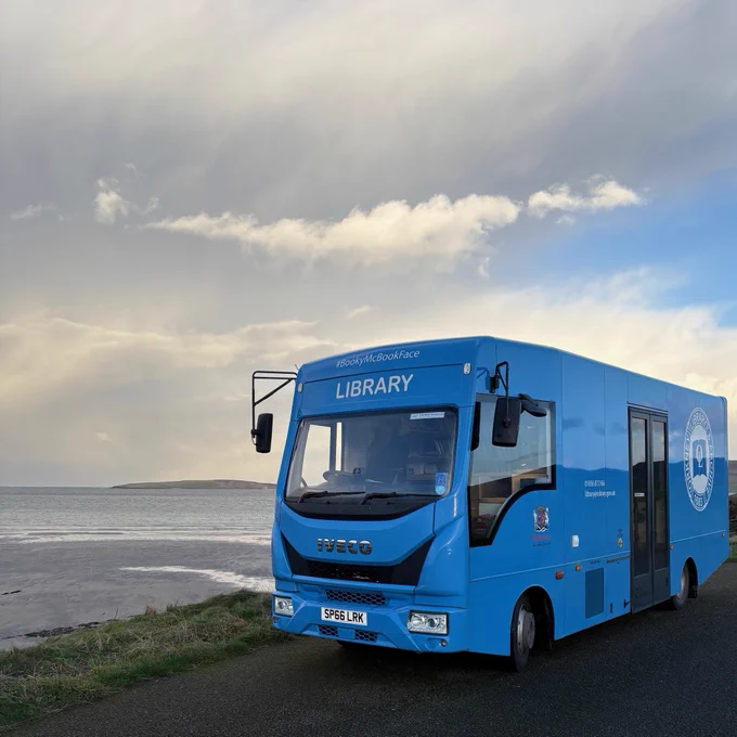 BookyMcBookface our Mobile Library parked up beside the sea