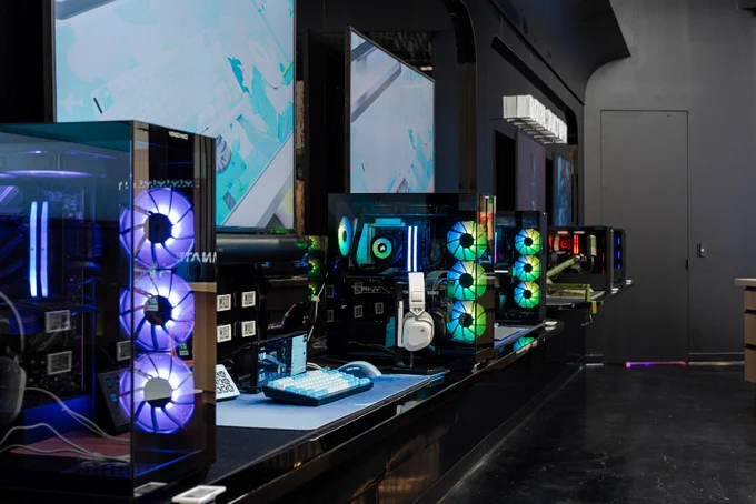 A row of CORSAIR PC builds inside the CORSAIR Experience Store, featuring colorful LED lighting across several PC towers.