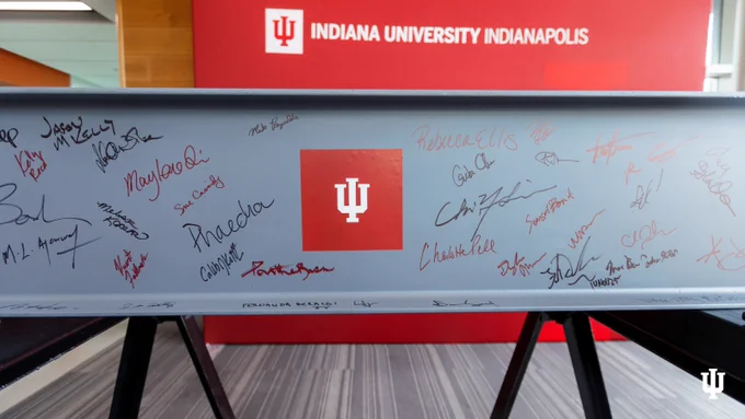 A bench at Indiana University Indianapolis featuring numerous signatures scrawled across its surface in various ink colors.