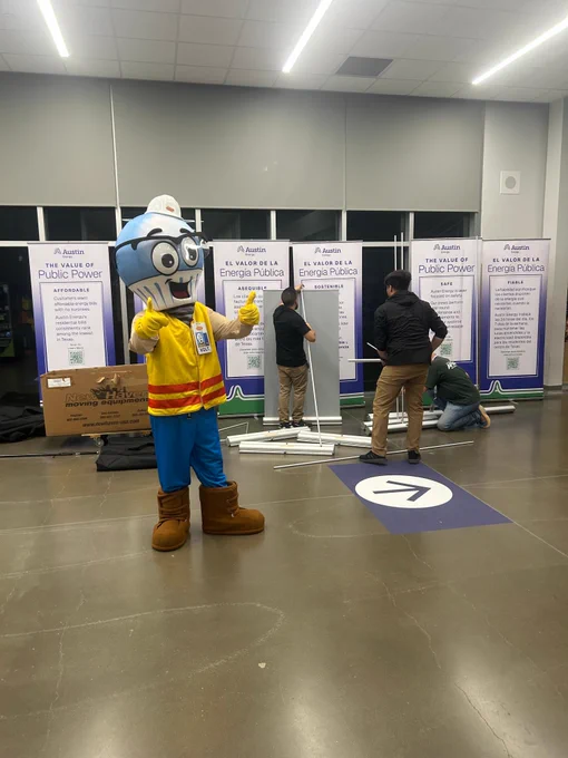 Austin Energy employees set up a signs and banners for a community fair. 