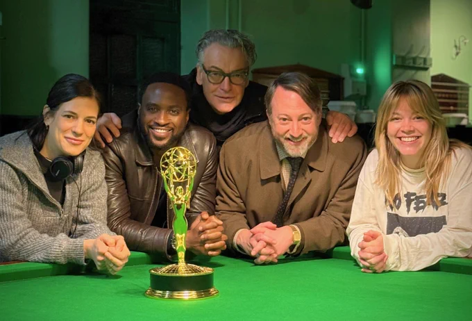 Georgie Fallon, Dipo Ola, Kenton Allen, David Mitchell and Anya Wilson lean against a snooker table, on which is standing an Emmy statuette