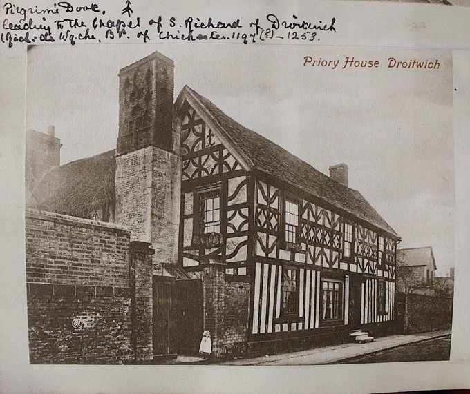 a half timbered house with a stone and brick chimney.