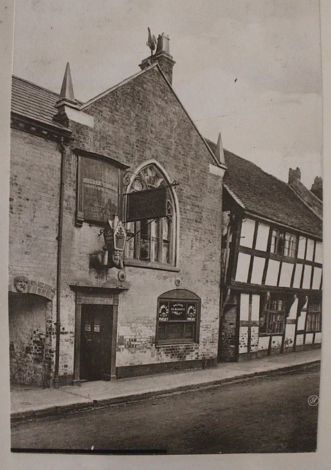 An old Inn with a half timbered house beside it.