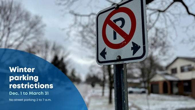 No parking sign on a snow covered road.