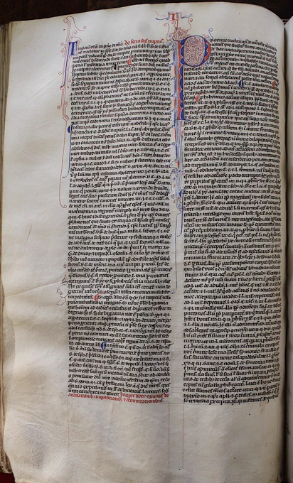 The page is divided into two columns of text. The right hand column starts with a red and blue letter P decorated in a zig-zag pattern. Red and blue flourishes also extend off the letter at the top and bottom. There are no annotations in the margins although one medieval user has scribbled a stylized face on the edge of the left hand column next to something he found useful.