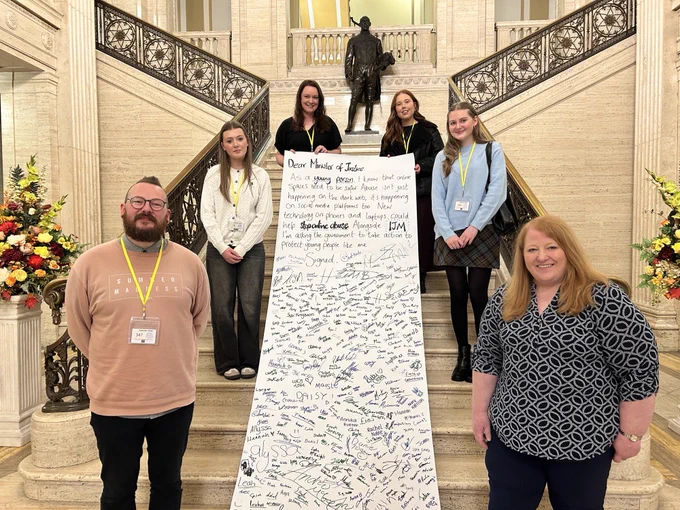 Young advocates of the Tech that Protects campaign pictured with  Justice Minister Naomi Long .