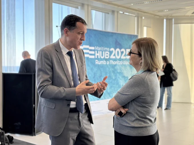 El conseller Ordeig parla amb una professora de la UPC davant del photocall del Maritime Hub