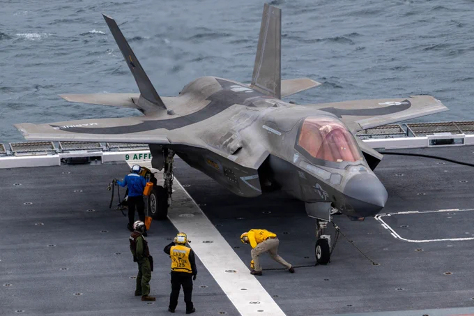 U.S. Sailors with the USS Tripoli, Task Force 76 unchain a U.S. Marine Corps F-35B Lightning II aircraft with Marine Fighter Attack Squadron (VMFA) 242, Marine Aircraft Group 12, 1st Marine Aircraft Wing, in preparation for flight operations aboard the JS Kaga during exercise ANNUALEX Oct.19, 2025. The exercise supports both force’s mission to strengthen interoperability, enhance joint maritime strike capabilities and maintain readiness in support of a free and open Indo-Pacific. (U.S. Marine Corps photo by Cpl. Alejandra Vega)
