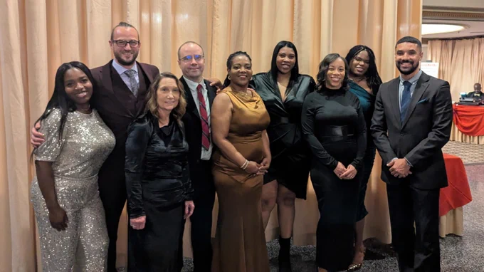 Group of eight individuals from the Maryland Stadium Authority posing in formal attire the recent Maryland Minority Contractors Association 12th Soirée & Awards Banquet​. 