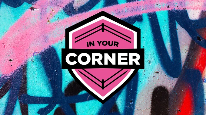 Pink shield emblem with the words 'IN YOUR CORNER' on a colorful graffiti wall background.